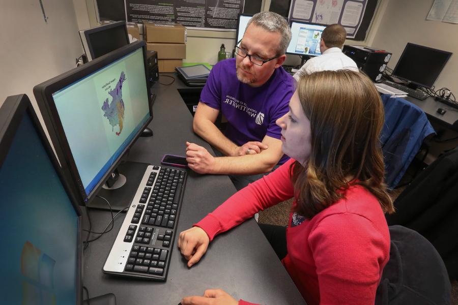 John Frye works with a student on a computer.